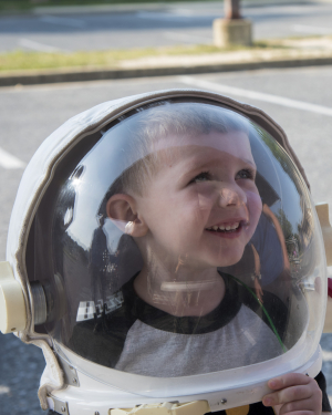 A child tries on an astronaut helmet 
