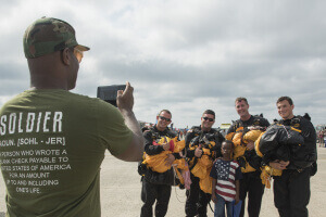 U.S. Army Parachute Team “Golden Knights” members pose with an air show attendee during the 2017 Joint Base Andrews Air Show