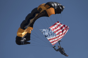 A member of the Army Golden Knights parachute team descends upon the crowd with the American flag at the 2017 Andrews Air Show